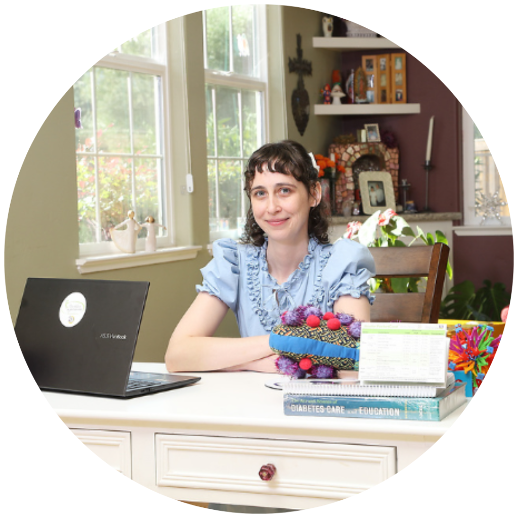 Woman at desk with laptop and books.