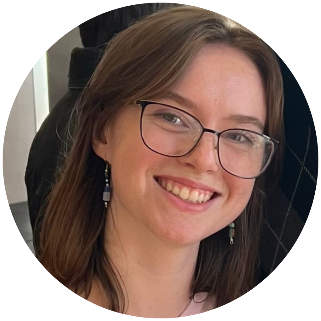 Young woman smiling with glasses and earrings.
