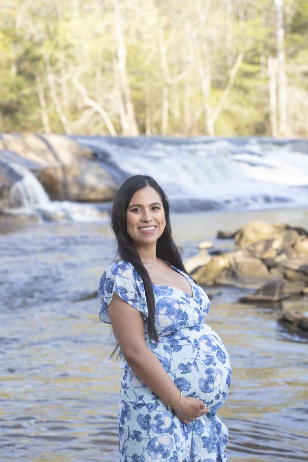 Pregnant woman smiling by a river