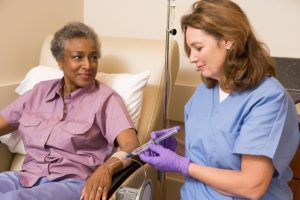 Nurse administering IV therapy to patient