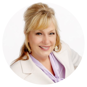 Smiling woman in white blazer and lavender blouse