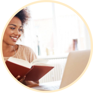 Woman reading book and using laptop