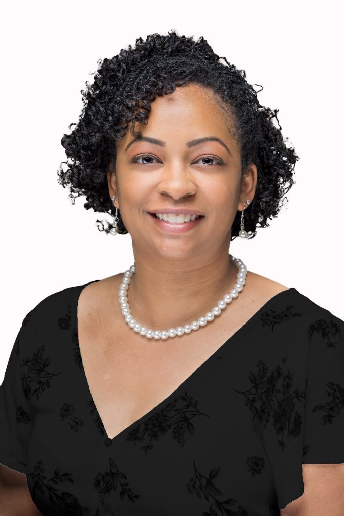 Smiling woman with curly hair and pearl necklace