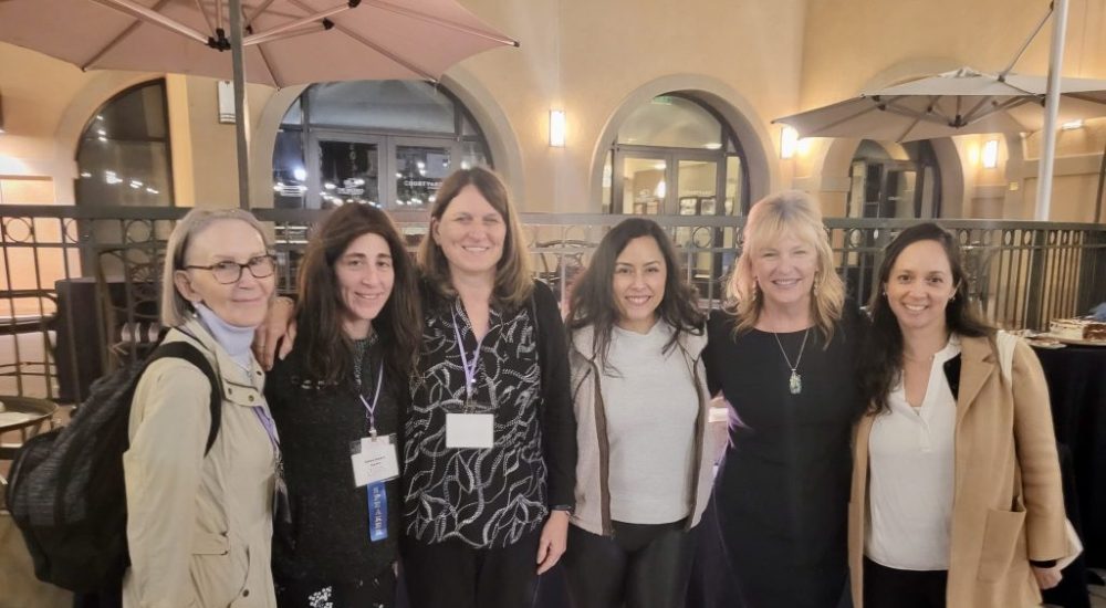 Group of women posed at an indoor event.